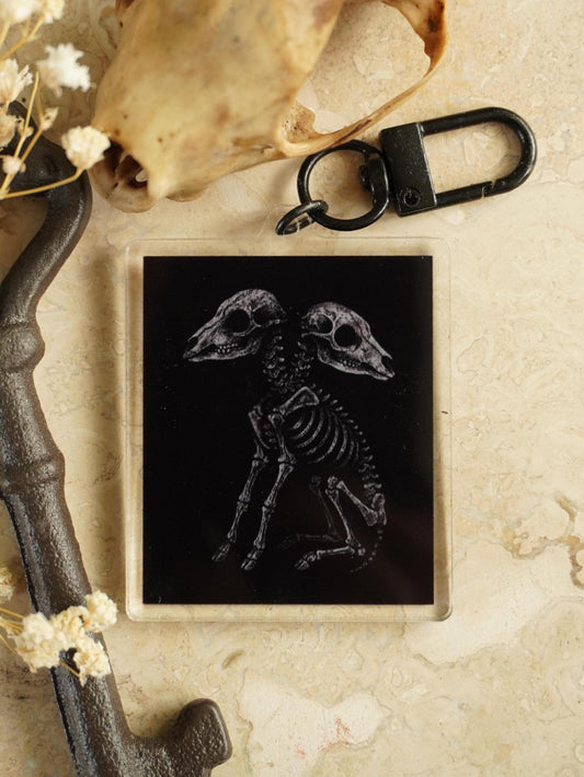 Keychain with a 2 headed lamb skeleton design on a black background