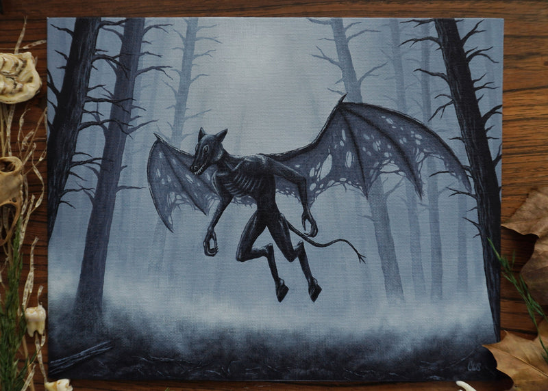 Painting of a winged creature in a forest on a wooden surface with natural elements.