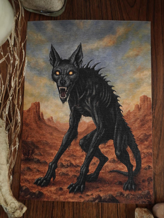 Painting of a chupacabra in a desert landscape on a wooden surface.