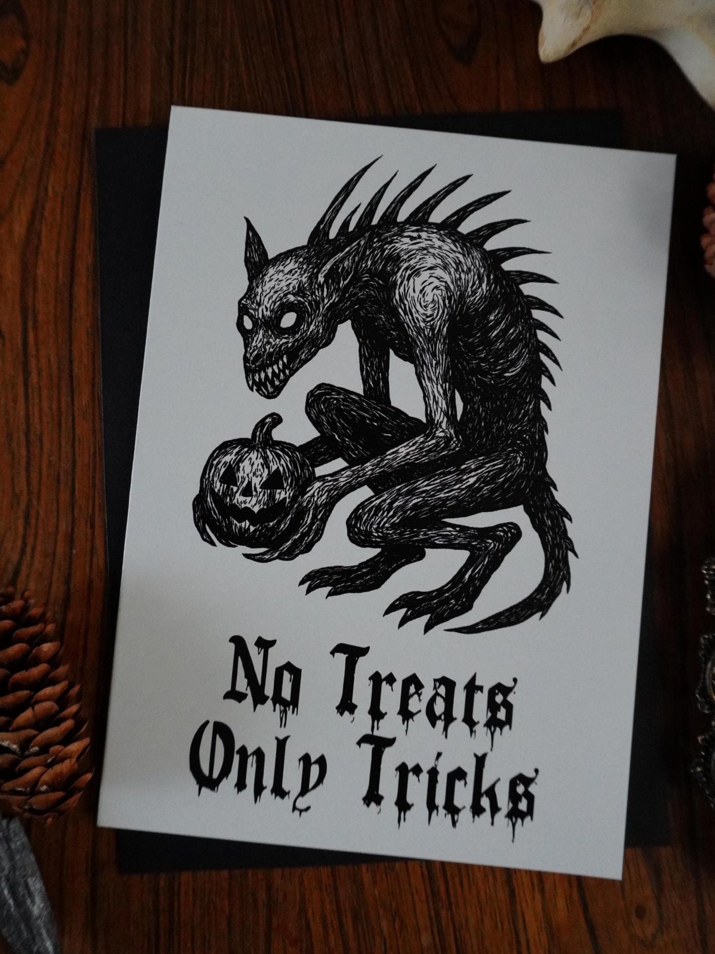 Halloween-themed print with a creature and pumpkin. a chupacabra holding a jackolantern with the words no tricks only treats