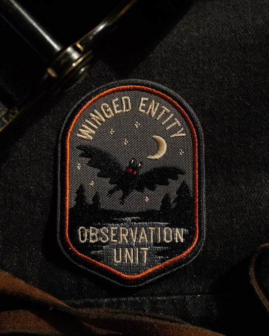 Patch on a jacket with 'Winged Entity Observation Unit' design with mothman